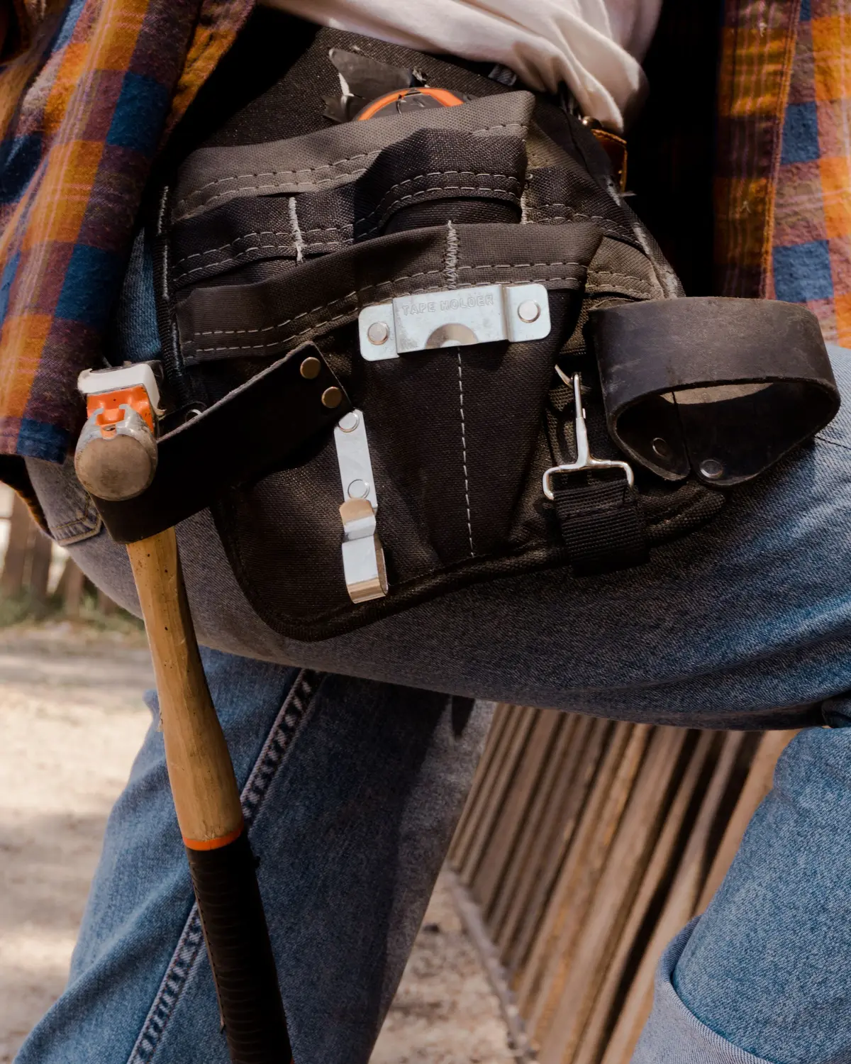 Leather tool belt holding a hammer and hand tools